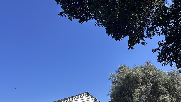 A white building with a sign reading "Barlocker’s Rustling Oaks Ranch" and a white picket fence. - Tranquil studio with WiFi in sunny outskirts Salinas (Salinas)