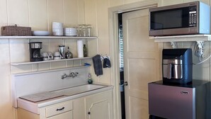 A compact kitchen with white cabinetry, a microwave, a coffee maker, and a refrigerator. - Tranquil studio with WiFi in sunny outskirts Salinas (Salinas)