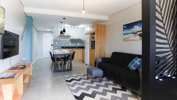 A modern living space with a dining area, kitchen, and seating area.