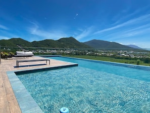 A swimming pool with a view of mountains and a town.