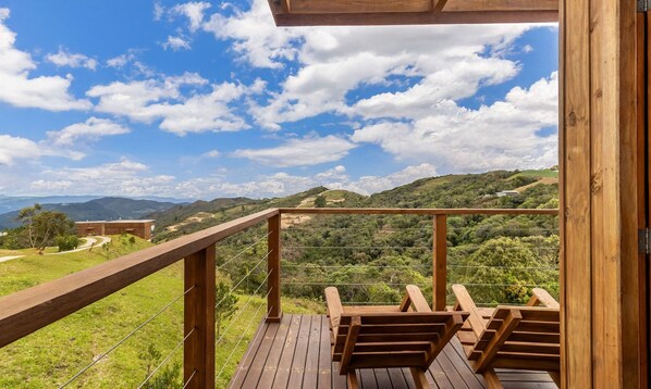A wooden deck with lounge chairs overlooking a mountainous landscape. - Charmosa cabana na serra VST005 (Anitapolis)