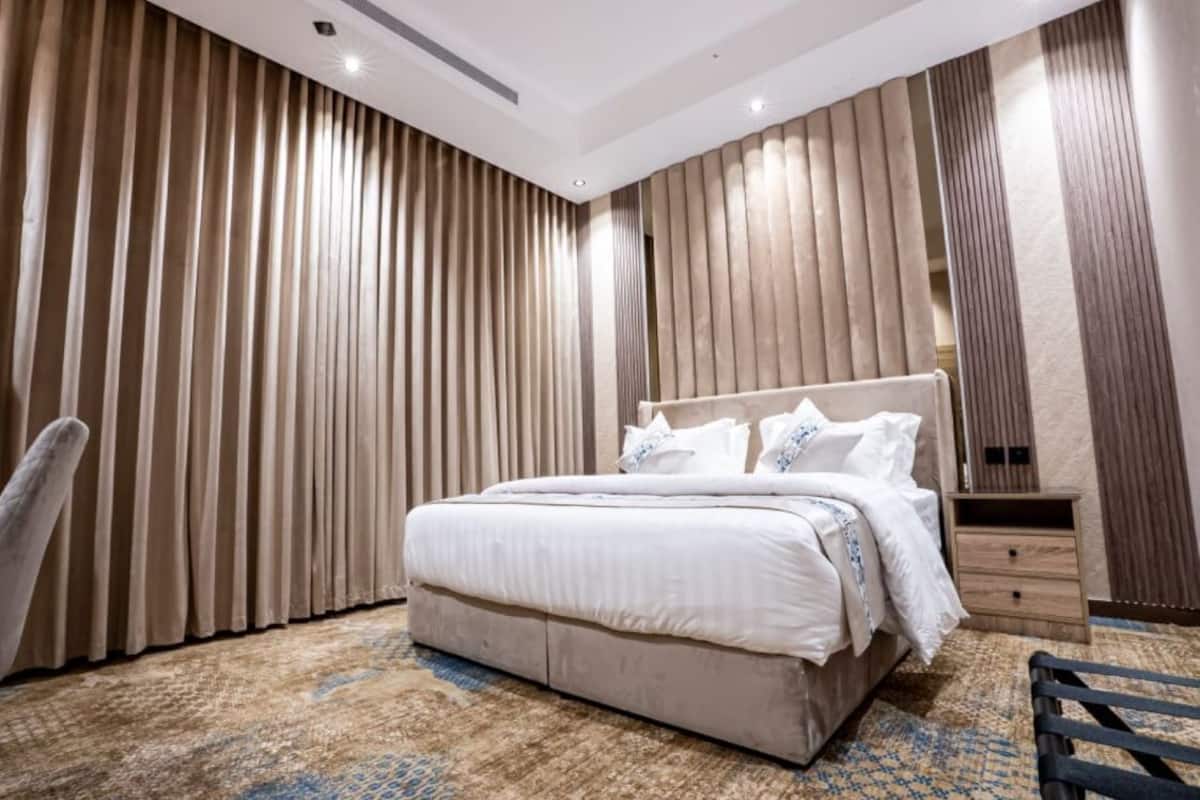 A modern bedroom with a large bed, a nightstand, and a chair.