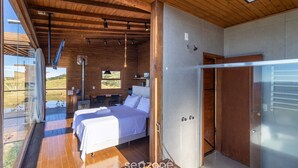 Une chambre moderne avec deux lits, un plafond en bois et une grande fenêtre donnant sur un paysage pittoresque.