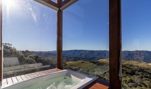 Uma banheira de hidromassagem em um deck de madeira com vista para as montanhas.