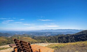 A wooden bench overlooking a mountainous landscape with clear skies. - Cabana com vista panorâmica VST006 (Anitápolis)