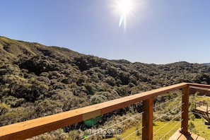 A wooden deck with a view of a forested hillside. - Cabana vista deslumbrante serra VST020 (Anitápolis)