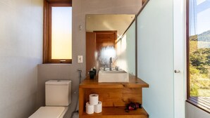 A bathroom with a toilet, sink, and shower. - Cabana vista deslumbrante serra VST020 (Anitápolis)