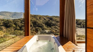 A hot tub on a wooden deck with a view of a forested hillside. - Cabana vista deslumbrante serra VST020 (Anitápolis)