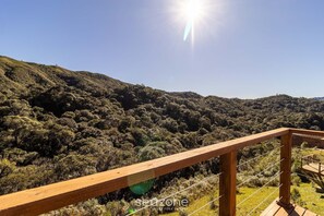 A wooden deck with a view of a forested hillside. - Cabana vista deslumbrante serra VST020 (Anitápolis)