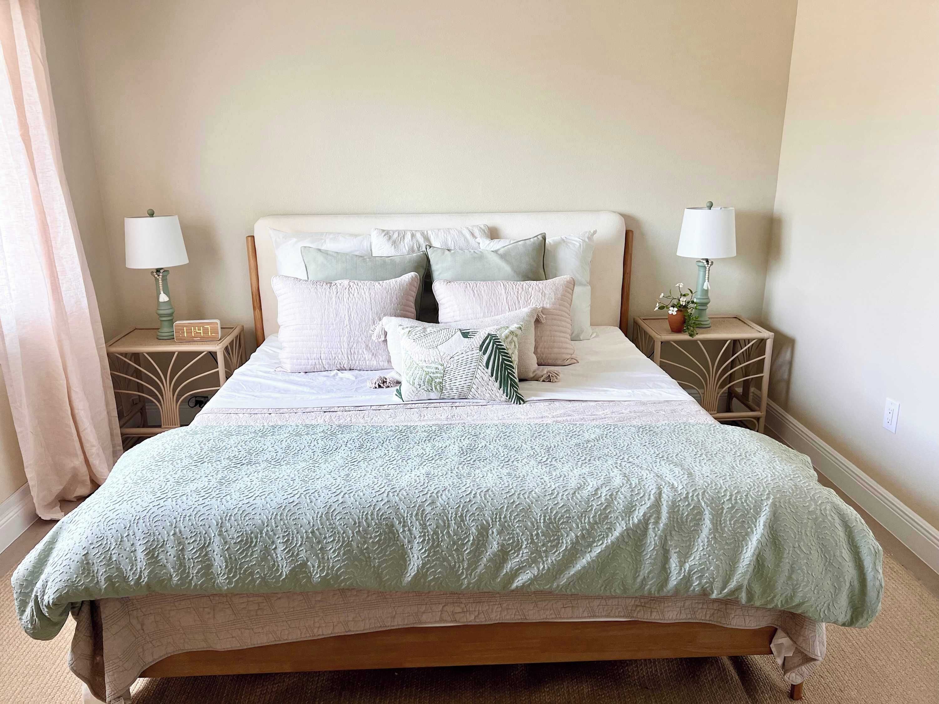 Relax in this serene bedroom featuring a soft green quilt and coordinating pillows for a restful stay.