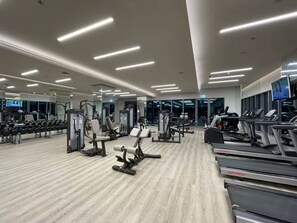 A modern gym with various exercise equipment, including treadmills and weight machines.