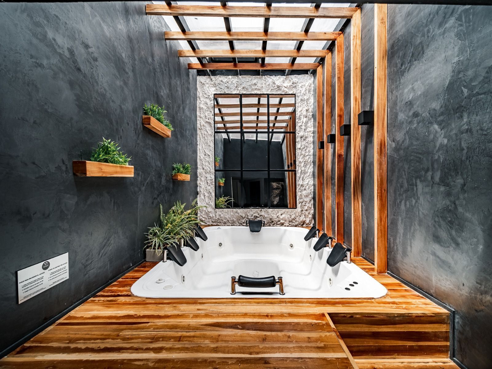 Une salle de spa moderne avec une grande baignoire, des poutres en bois et des plantes en pot.