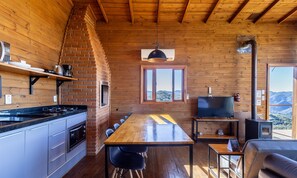 Een gezellig vakantiehuisje met keuken, eethoek en televisie.