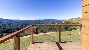 A wooden deck with a view of a mountainous landscape. - Cabana vista panorâmica e jacuzzi VST022 (Anitápolis)