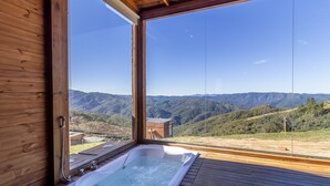 A wooden cabin with a hot tub and a view of a mountainous landscape. - Cabana vista panorâmica e jacuzzi VST022 (Anitápolis)