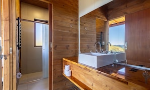 A modern bathroom with a wooden interior, a large mirror, and a view of the outdoors. - Cabana vista panorâmica e jacuzzi VST022 (Anitápolis)