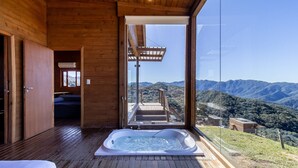 A wooden cabin with a hot tub and a view of a mountainous landscape. - Cabana vista panorâmica e jacuzzi VST022 (Anitápolis)