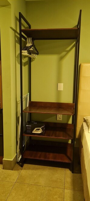 A bunk bed with a shelf unit above it, containing a box labeled "Electrolux BASE VAPOR EXTRA" and a hanging rack with clothes. - CJC Short Stay Ilusion (Natal)