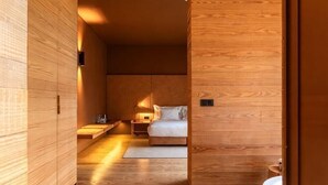 A wooden interior with a bed, bedside table, and a nightstand. - Monverde - Wine Experience Hotel - by Unlock Hotels (Borba de Godim)
