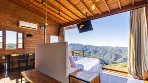 Una cabaña de madera con una cama, una mesa y un televisor.