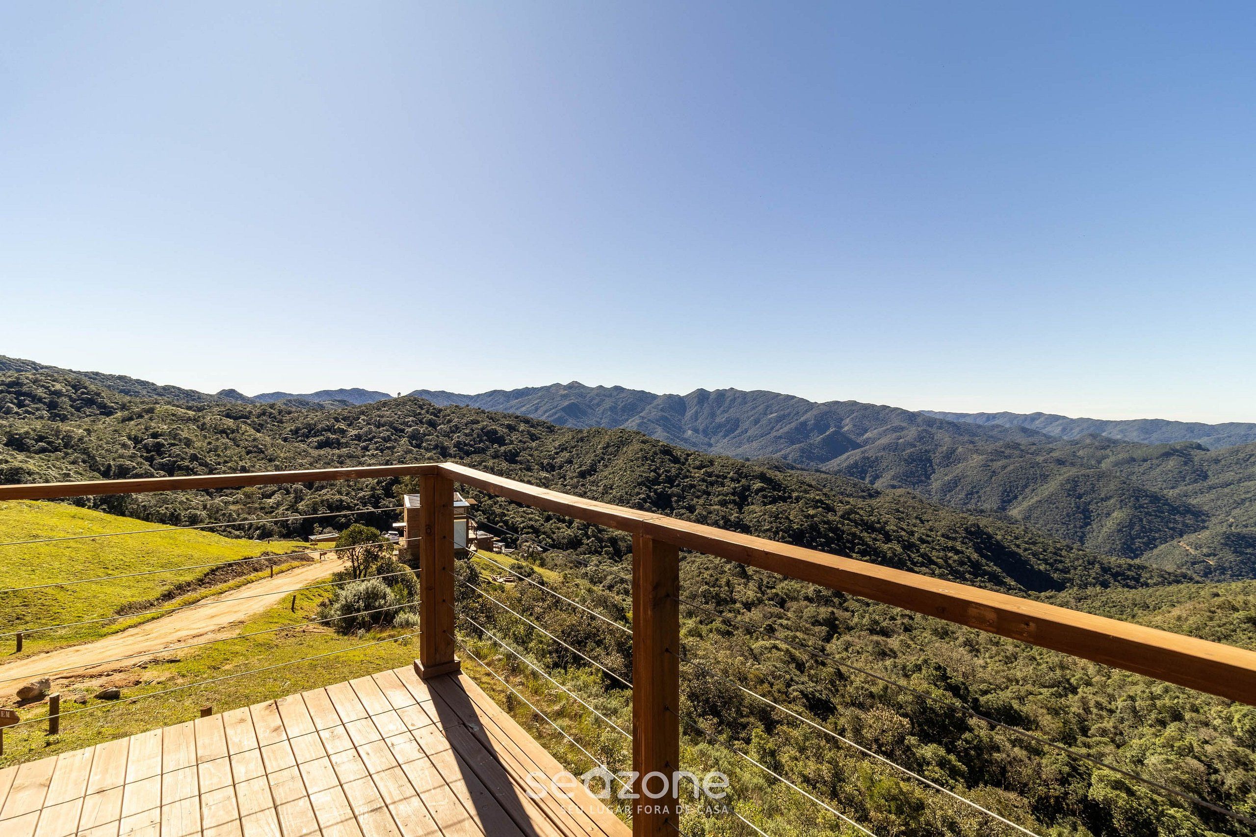 Una terraza de madera con vistas a un paisaje montañoso.