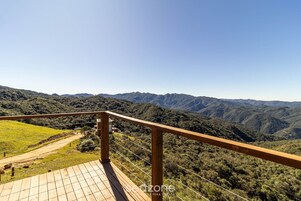 Una terraza de madera con vistas a un paisaje montañoso.