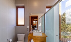 A modern bathroom with a toilet, sink, and shower.