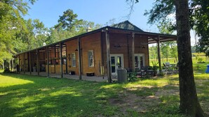 A wooden cabin with a covered porch, large windows, and a door. - Romantic Barn I Chickens, Porch, Near City,
Dog Friendly (Hollywood)
