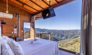 Une chambre avec une grande fenêtre donnant sur un paysage montagneux.