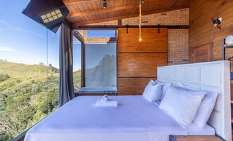 Un dormitorio con una cama grande, vistas al campo y techo de madera.