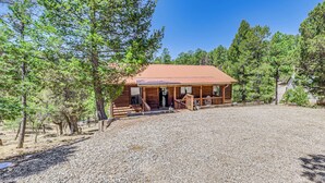 Une cabane en bois avec une allée en gravier et un porche abrité.