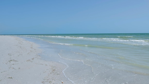 A beach with clear blue water and a sandy shore. - Estero Beach & Tennis 1001-a (Fort Myers Beach)