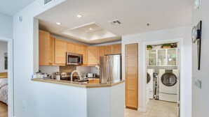 A compact kitchen with wooden cabinets, stainless steel appliances, and a central island. - Near Golf & Trails! Pet-Friendly Scottsdale Condo (Scottsdale)