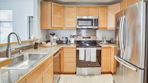 A modern kitchen with wooden cabinets, stainless steel appliances, a granite countertop, and a built-in oven. - Near Golf & Trails! Pet-Friendly Scottsdale Condo (Scottsdale)