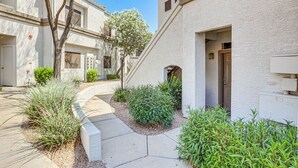 A residential building with a narrow driveway, a tree, and a small garden area. - Near Golf & Trails! Pet-Friendly Scottsdale Condo (Scottsdale)