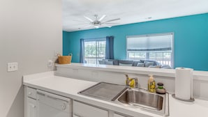 A kitchen with a white countertop, stainless steel sink, and a ceiling fan. - 1 Mi to Beach, Near Golf! North Myrtle Beach Condo (North Myrtle Beach)