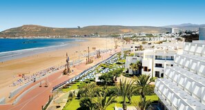 A coastal hotel with a beach view, a running track, and a landscaped garden.