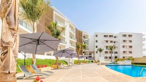 A modern hotel with a swimming pool, sun loungers, and umbrellas. - Agadir Bay Beautiful apartment overlooking the pool and nearby beach. (Agadir)