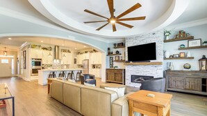 A spacious living area with a large sofa, wooden coffee table, and a fireplace. - West ATL Home w/ Great Outdoor Space: 4 Mi to Dtwn (Atlanta)