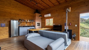 Un acogedor interior de cabaña con kitchenette, un sofá y una chimenea.