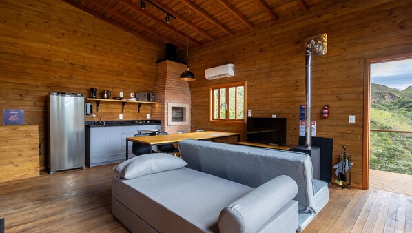 Un acogedor interior de cabaña con kitchenette, un sofá y una chimenea.