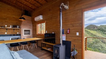 Een houten cabin met een keuken, eethoek en een open haard.