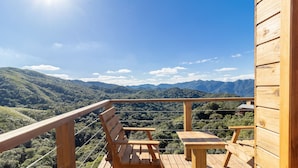 A wooden deck with a bench and table, overlooking a mountainous landscape. - Chalé c\ Jacuzzi prox. de Florianópolis VST028 (Anitapolis)