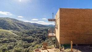 A wooden cabin with a balcony overlooking a forested valley. - Chalé c\ Jacuzzi prox. de Florianópolis VST028 (Anitapolis)