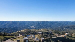 A mountainous landscape with buildings and a clear sky. - Chalé c\ Jacuzzi prox. de Florianópolis VST028 (Anitapolis)