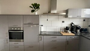 Una cocina moderna con electrodomésticos de acero inoxidable, una encimera de madera y una planta en maceta.