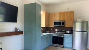 Una cocina moderna con armarios de madera, electrodomésticos de acero inoxidable y un horno empotrado.