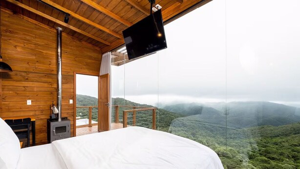Une chambre à coucher avec un lit, une télévision et une vue sur un paysage montagneux.