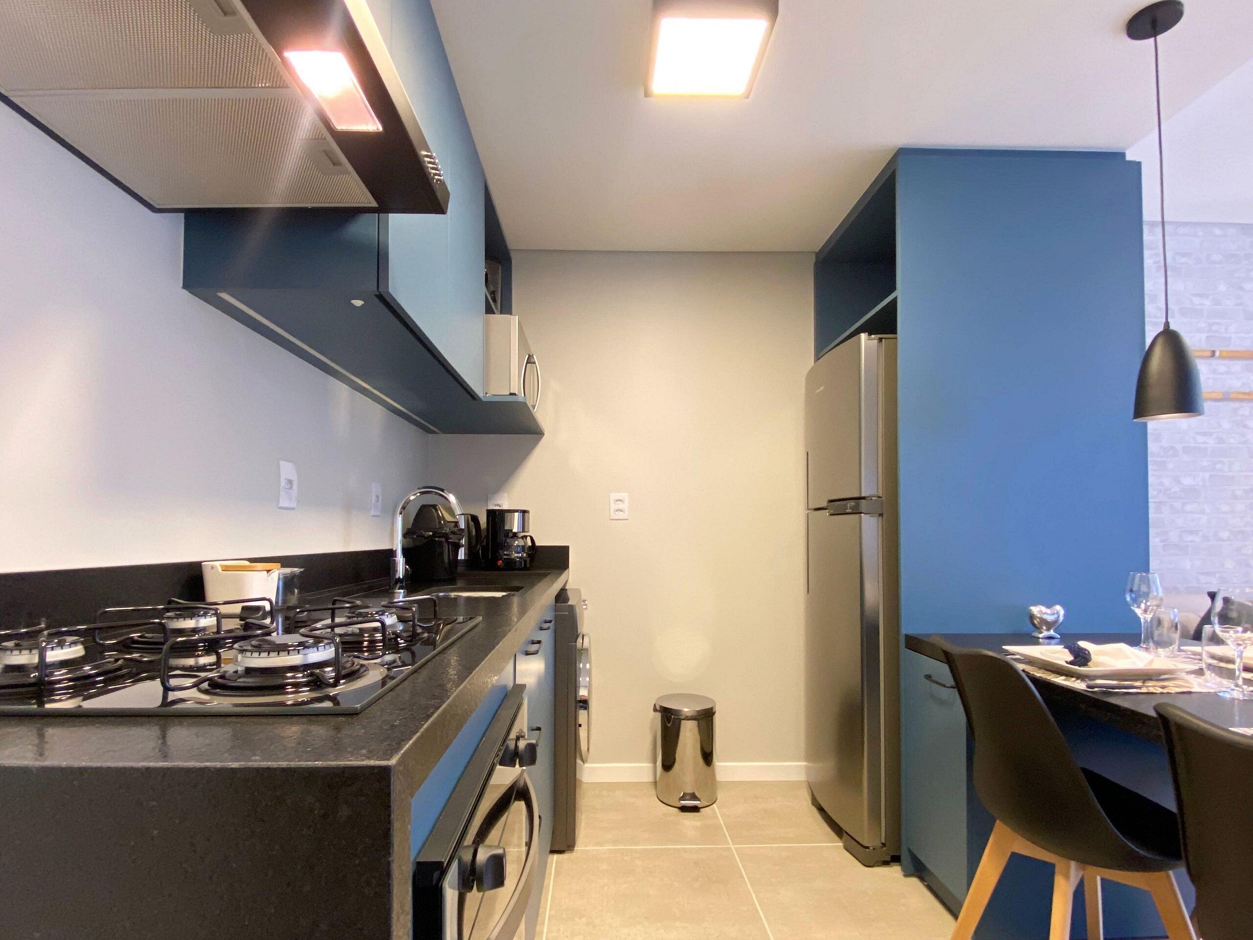 Una cocina moderna con estufa a gas, horno y refrigerador de acero inoxidable.