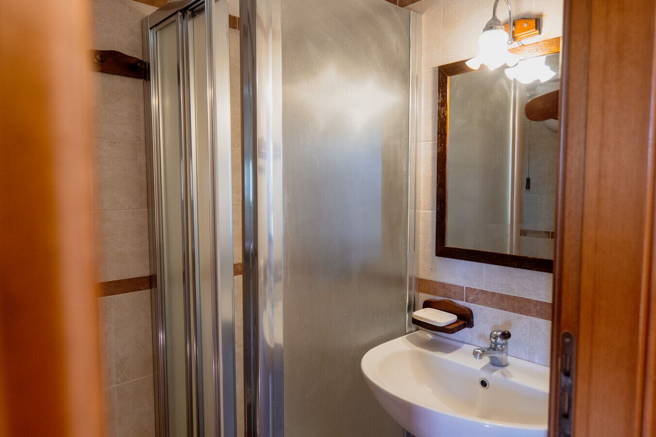 Une salle de bain avec une douche, un lavabo et un miroir.